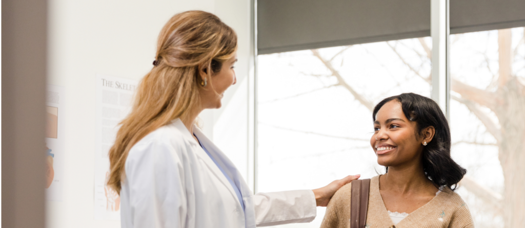 Doctor comforting a smiling patient. Hematology consultation available.